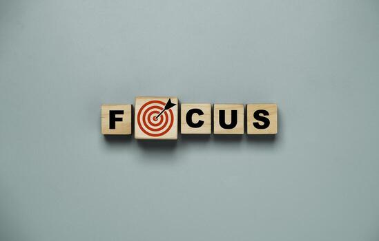 Top view or flat lay design of focus wording on wooden cube block with red dartboard and arrow drawing for concentrate with business objective target concept. photo