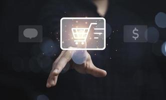 Businessman touching to shopping trolley cart icon for online shopping and e-commerce business concept. photo