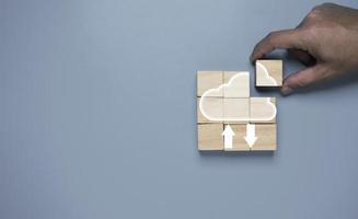 Hand holding wooden cube block to assemble cloud computing , Cloud technology use for storage and sharing big data and information , Digital Technology transformation concept. photo