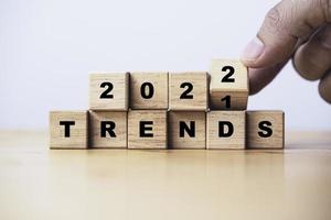 voltear a mano para cambiar la tendencia de 2021 a 2022 para el concepto de tendencia de moda y negocios de año nuevo. foto