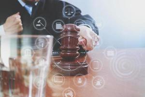 justice and law concept.Male judge in a courtroom with the gavel,working with smart phone,digital tablet computer docking keyboard on wood table,virtual interface graphic icons diagram photo