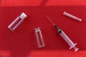 Medical syringe tablets and glass bubbles on a red background