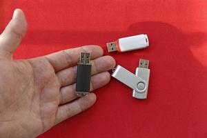 unidad flash usb en la palma de la mano sobre un fondo rojo foto