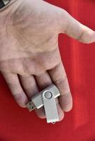 USB flash drive in the palm of your hand on a red background photo