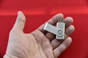 unidad flash usb en la palma de la mano sobre un fondo rojo foto