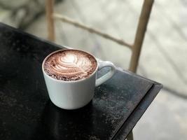 taza de café caliente en la mesa de madera en el restaurante foto