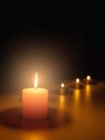 enciende una vela en la oscuridad, la llama se calienta y la luz crea un bokeh. la luz y la sombra crean la atmósfera. cosas como románticas, misteriosas, interesantes y también te hacen sentir fe.