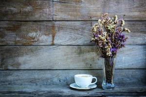 Coffee cup and vase at wall. photo
