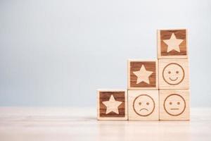 emotion face and Star symbol blocks on table background. Service rating, ranking, customer review, satisfaction, evaluation and feedback concept photo