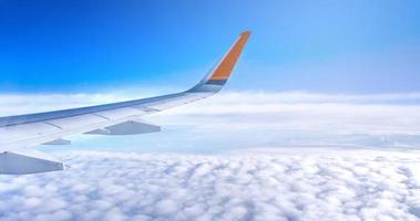 Bussiness and travel concept. Aerial view through window inside aircraft cabin with beautiful blue sky and cloud with sunlight, copy space, top view photo