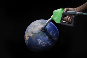 world oil economic Concept image of the world oil condition from the hand refueling oil pump nozzle photo