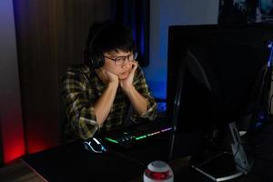 el jugador asiático con auriculares estresado con la mano se siente deprimido o enojado cuando pierde el videojuego en la computadora miedo y malestar por error, tecnología de videojuegos y concepto de deporte electrónico