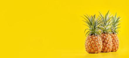 Beautiful fresh pineapple isolated on bright yellow background, summer seasonal fruit design idea pattern concept, copy space, close up photo