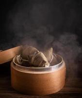 Zongzi, steamed rice dumplings in steamer on wooden table, famous tasty food in dragon boat festival duanwu design concept, close up, copy space.