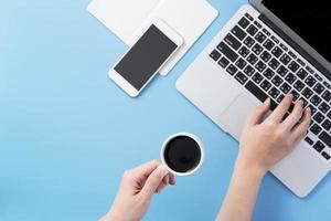 mujer navega por internet para buscar trabajo. escritor de blog independiente escribiendo en un escritorio azul claro limpio con café, espacio de copia, plano, vista superior, maqueta