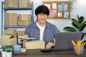 Asian business man startup SME entrepreneur or freelance working in a cardboard box prepares delivery box for customer, Online selling, e-commerce, packaging and shipping concept.