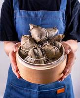 Zongzi, delicious steamed rice dumplings in steamer in black background for dragon boat duanwu festival, close up, copy space, top view, flat lay photo