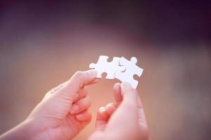 Hands and white jigsaw puzzles Close-up image and integration Business concept and unity photo