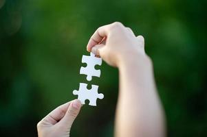 Hands and white jigsaw puzzles Close-up image and integration Business concept and unity photo