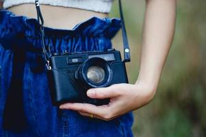 mano y cámara del fotógrafo sosteniendo y llevando la cámara para tomar fotografías foto