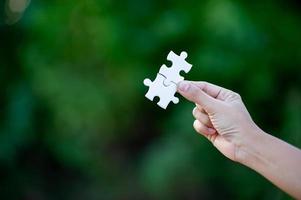 Hands and white jigsaw puzzles Close-up image and integration Business concept and unity photo