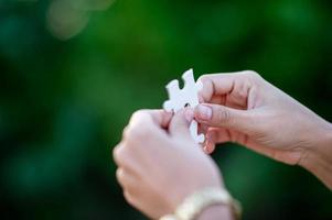 Hands and white jigsaw puzzles Close-up image and integration Business concept and unity photo