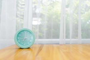 despertador verde claro colocado sobre la mesa en el dormitorio foto