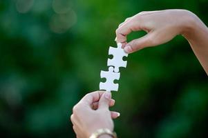 Hands and white jigsaw puzzles Close-up image and integration Business concept and unity photo