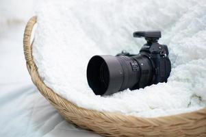 The black camera is well placed in a white cloth. photo
