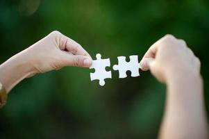 Hands and white jigsaw puzzles Close-up image and integration Business concept and unity photo