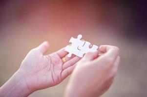 Hands and white jigsaw puzzles Close-up image and integration Business concept and unity photo