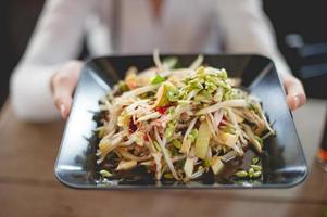 Hand and papaya salad, the taste of Thai people, food that is spicy, food concept photo