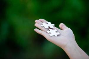 Hands and white jigsaw puzzles Close-up image and integration Business concept and unity photo