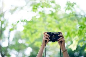 fotógrafo y amante de la cámara cámara negra y fondo verde natural foto
