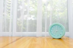 Light green alarm clock Placed on the table in the bedroom photo