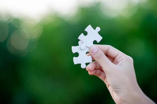 Hands and white jigsaw puzzles Close-up image and integration Business concept and unity photo