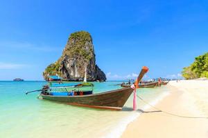 Long tail boat and turquoise crystal clear sea water with limestone cliff and mountain at Phra Nang Beach, Krabi, Thailand photo