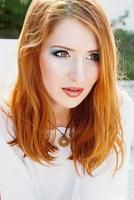 Portrait of young beautiful red-haired woman in sunny day photo