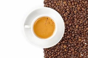 Cup of coffee on a background of beans and on white, top view photo