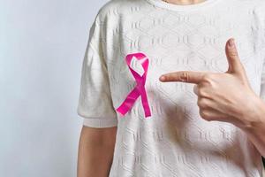 A pink badge ribbon on woman chest to support breast cancer cause photo