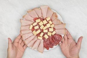 Smoked Meat and Sausages served with Cheese on the plate photo