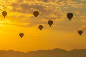 grupo de globos aerostáticos que vuelan sobre la llanura de bagan por la mañana. bagan ahora es el sitio del patrimonio mundial de la unesco y el primer reino de myanmar. foto