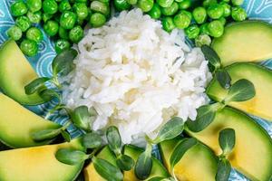 Closeup white rice with avocado, green peas and sunflower microgreen photo
