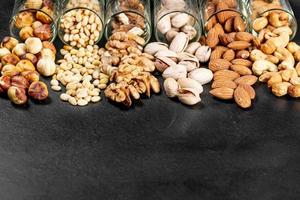 Pistachios, almonds, cashews, walnuts, pine nuts and hazelnuts on a black background photo