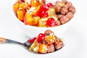 Spoon with chocolate corn balls and fruit slices photo