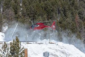 granvalira, andorra. 16 de marzo de 2022. helicóptero de servicio turístico aterrizando en la estación de esquí de grandvalira en el invierno de 2022 foto