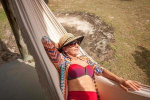 Woman near the beach in Caraiva, Brazil relaxing in a hammock in Swimwear photo