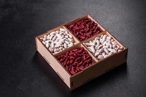 Beans of red and white dry raw beans on a dark concrete background