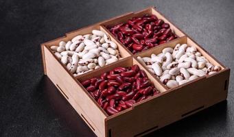 Beans of red and white dry raw beans on a dark concrete background