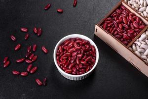 Beans of red dry raw beans on a dark concrete background